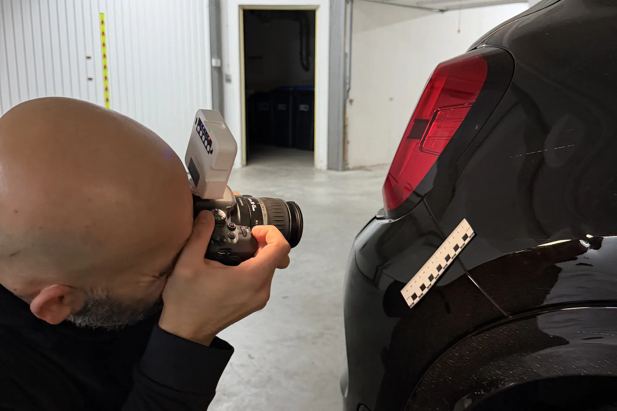 Gutachter fotografiert einen Schaden mit Maßstab